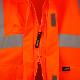 Close-up of high visibility orange GORE-TEX work jacket with two-way zip and reflective tape